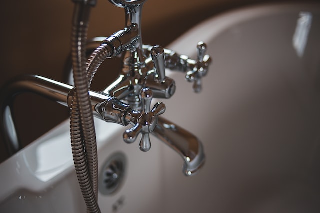 Close up of silver bathtub handles in a white bathtub